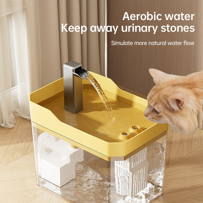 Cat drinking from a transparent yellow tray water fountain with stainless spout and stream