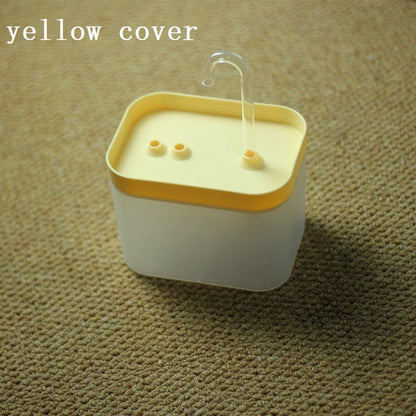 Automatic cat water fountain with yellow top, clear spout, and recirculating water bowl