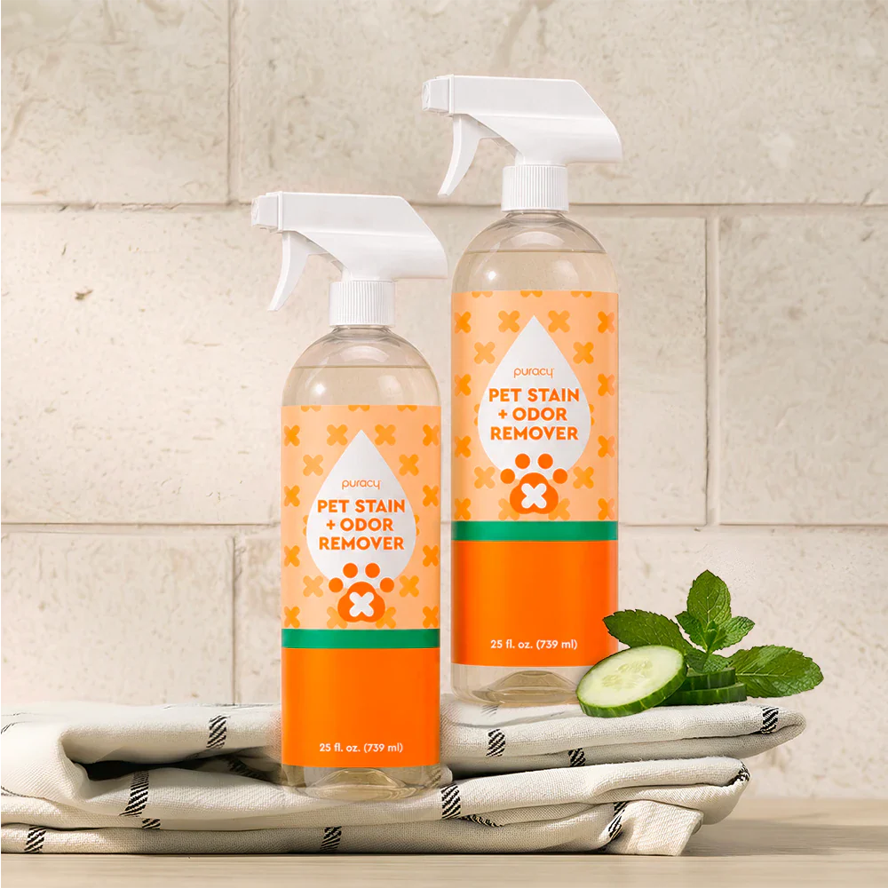 Two Pet Stain & Odor Remover spray bottles with cucumber-mint scent on towels