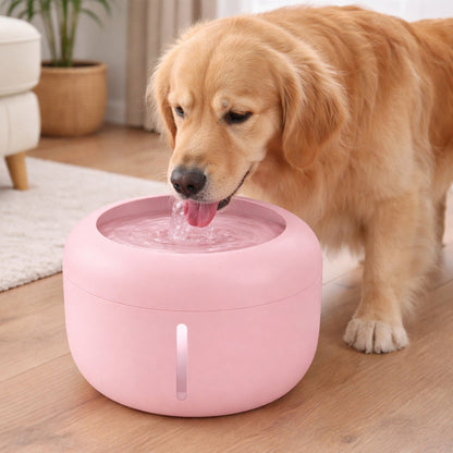 Pink pet water fountain on floor with dog drinking from the spout