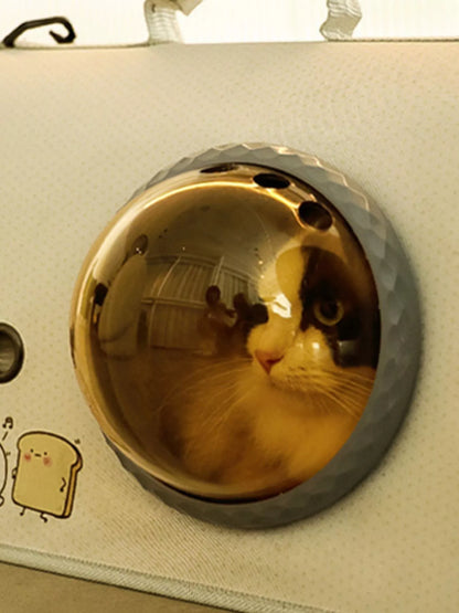 Close-up of gold-tinted round bubble window on a pet carrier bag