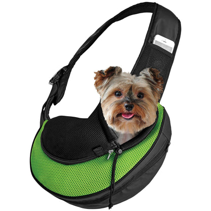 Green and black expandable pet sling carrier with mesh front, holding a small dog.